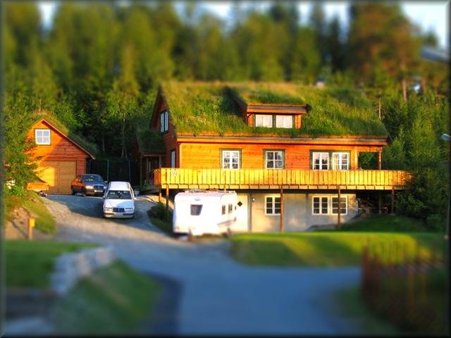Huset på Villmarkstoppen med torvtak, fotografert med tilt-shift-effekt